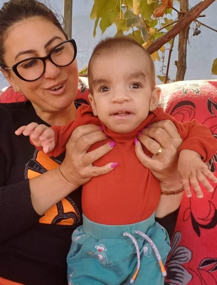 image of a social case where the association president holds in her arms a small child who is a victim of autism supported by the association
